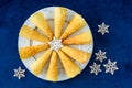 Handmade Krumkake waffle cookies on a round white plate with a snowflake pattern, decorative snowflakes, on a dark blue background Royalty Free Stock Photo