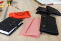 Handmade leather wallets and notebook lying on table near tools. Royalty Free Stock Photo
