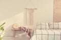 Handmade macrame on empty white wall of scandinavian bedroom interior