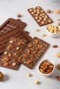 Handmade milk chocolate bars with nuts and dried fruits with molds and ingredients on white background. Side view Royalty Free Stock Photo