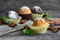 Handmade muffins with a leaf of mint on a wooden table with cinnamon and star anise