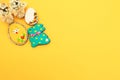 Handmade multi-colored gingerbread cookies in the form of a bunny and Easter eggs, straw shoes and flowers on a yellow Royalty Free Stock Photo