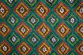 Handmade multicolor carpet with rhombus ornament, braided mat, closeup, texture background