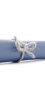 Handmade natural cord knot tied on blue paper scroll isolated Royalty Free Stock Photo