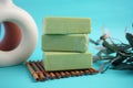Handmade olive soap stacked on bamboo mat with plant background Royalty Free Stock Photo