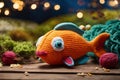 Handmade orange fish toy. Knitted kid soft toy made yarn on an artificial water bottom
