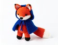 Handmade Orange and White Knitted Fox Plush Toy with Blue Cape on White Background Royalty Free Stock Photo