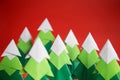 Handmade origami paper craft Christmas tree on red background