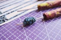 Handmade paper bead template of black colored floral pattern being rolled on a rolling tool on a purple cutting mat Royalty Free Stock Photo