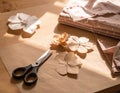 Handmade Paper Flowers and Fabric Stack on Table Lit by Sunlight Indoors Royalty Free Stock Photo