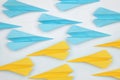 Handmade paper planes in light blue and yellow colors on white table, flat lay Royalty Free Stock Photo