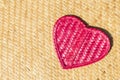 Handmade pink bamboo wood heart on reed mat background