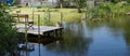 Handmade pond and wooden pier in poor Lithuanian village Royalty Free Stock Photo