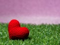 Handmade red yarn heart on Green grass background is royal pink.Copy space for text, Valentines day, love concept and love Royalty Free Stock Photo