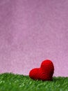 Handmade red yarn heart on Green grass background is royal pink.Copy space for text, Valentines day, love concept and love Royalty Free Stock Photo