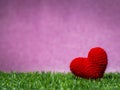 Handmade red yarn heart on Green grass background is royal pink.Copy space for text, Valentines day, love concept and love Royalty Free Stock Photo