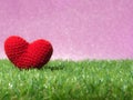 Handmade red yarn heart on Green grass background is royal pink.Copy space for text, Valentines day, love concept and love backgro Royalty Free Stock Photo