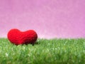 Handmade red yarn heart on Green grass background is royal pink.Copy space for text, Valentines day, love concept and love backg Royalty Free Stock Photo