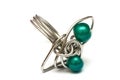 A handmade ring with silver metal and emerald green beads white backdrop