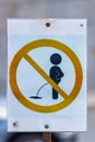 Handmade sign Do not pee closeup with wooden post on the city lawn in sunny day