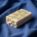Handmade soap bar with embedded oatmeal pieces displayed on a blue Royalty Free Stock Photo