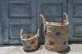 Handmade straw bags in front of a wooden door at street Royalty Free Stock Photo