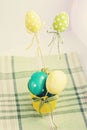 Handmade textile eggs and bird near the yellow bucket with polka dots eggs on a kitchen towel