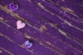 Handmade textile felt toy hearts on old violet wooden floor