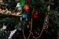 Handmade toys for Christmas tree decoration, an asterisk on green branches outdoors, toy made of wood, plaster and glitters,