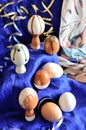 Handmade white and brown painted clay Easter eggs on a deep blue background with ribbons Royalty Free Stock Photo