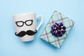 Handmade White male cup and gift box on blue background, father`s day present . step 4 Royalty Free Stock Photo