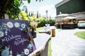 Handmade wooden board with welcome sign on it decorated with flowers outdoor