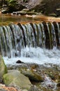 Handmade wooden water drains from small treated beams. A beautiful fragment of a small waterfall