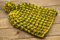 Handmade wool knitted winter yellow and green hat Royalty Free Stock Photo