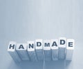 Handmade word on wooden blocks, light blue background. Hobby handmade goods concept, small retail business startup