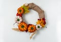 Handmade wreath made of textile pumpkins, Rowan berries and hawthorn, cereals and seeds on a white background. Isolated.