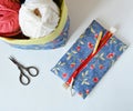 Handmade zipper pouch, crochet hook, fabric basket, yarns and scissors