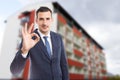 Handome real estate agent showing perfect gesture outdoors