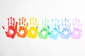 Handprints made with bright paints on background, top view. Rainbow colors