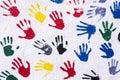 Handprints in yellow, blue, red, green, black on a white wall, background Royalty Free Stock Photo