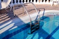 Handrail on the pool. Swimming pool with stair closeup. Royalty Free Stock Photo