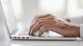 Hands actively typing on a laptop's keyboard situated in a bright and modern workspace, illustrating the themes of network Royalty Free Stock Photo