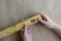 The hands of an adult Caucasian man holds a yellow building level Royalty Free Stock Photo