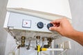 Hands adult men set the temperature of the water in the double-circuit gas boiler. Royalty Free Stock Photo