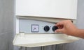 Hands adult men set the temperature of the water in the gas boiler. Royalty Free Stock Photo