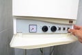 Hands adult men turning on of the water in the gas boiler. Close up of male hands turning on of a gas boiler.