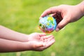 The hands of adults are passing the world to the hands of children, to continue to care and heal our planet. Royalty Free Stock Photo