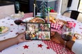 Hands of african american couple holding tablet with diverse families on screen