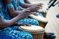 Hands of African drummers in blue costumes and traditional drums