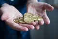 Hands of an aged man holding and showing many golden coins representing bitcoins. Concept investment in cryptocurrencies Royalty Free Stock Photo